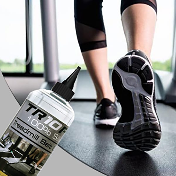 Close up shot of the 750ml TR10 Pro Silicone Treadmill Oil next to a treadmill in use